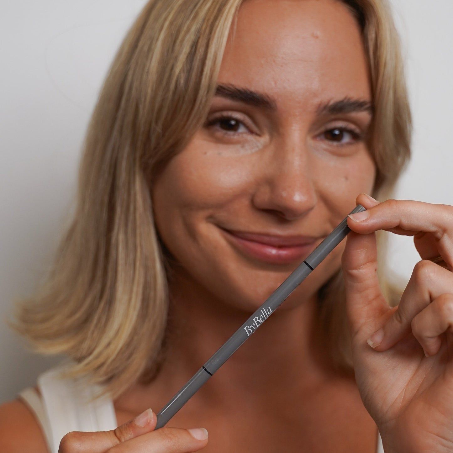 Brow pencil in hands. Front on